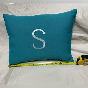 Turquoise pillow with embroidered white S.